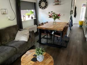 ein Wohnzimmer mit einem Sofa und einem Tisch in der Unterkunft Chalet bosrijk Midden in de natuur-eten&drinken-activiteiten-ontspanning-huisdieren welkom-en nog veel meer in Hoenderloo