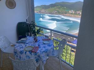 una mesa en un balcón con vistas al océano en El BALCON DE BAKIO, en Bakio