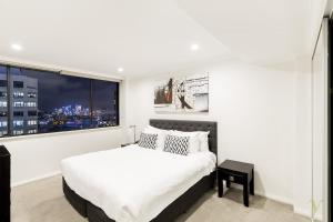 - une chambre avec un lit blanc et une grande fenêtre dans l'établissement The York by Swiss-Belhotel, à Sydney