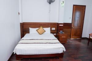 a bedroom with a large bed with a wooden headboard at Khách Sạn Như Mai in Quang Tri