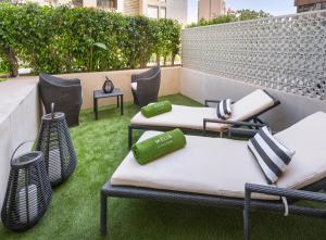 2 chaise longue e sedie su un patio erboso di Melia Sevilla a Siviglia