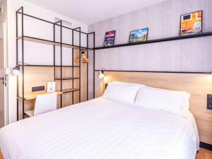 um quarto com uma grande cama branca e prateleiras em Ibis Roquebrune Cap Martin Menton em Menton