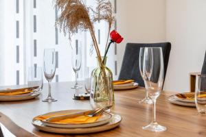 una mesa con gafas y un jarrón con una rosa. en Ferienwohnung Jasmin, en Leonberg