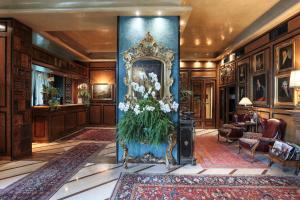 - un hall doté d'un pilier bleu avec un miroir et des fleurs dans l'établissement Hotel de la Ville Monza - Small Luxury Hotels of the World, à Monza