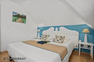 - une chambre avec un lit blanc et un mur bleu dans l'établissement Appartement Madinina 6 personnes vue sur mer dans village vacances, à Sainte-Luce