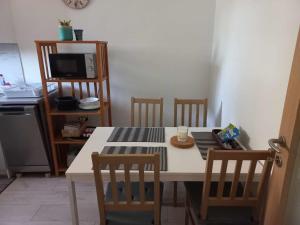 eine Küche mit einem Tisch, Stühlen und einer Mikrowelle in der Unterkunft Apartma Vita in Izola