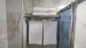 a bunch of towels on a towel rack in a bathroom at Dei Cozy Apartment in Shkodër