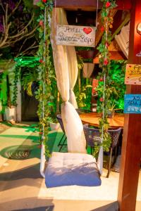 Cette chambre comprend une tente avec une chaise et des fleurs. dans l'établissement Pousada do Bispo, à Cabo Frio