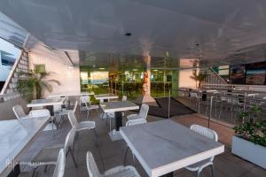 a restaurant with white tables and white chairs at Rede Andrade Solmar in João Pessoa