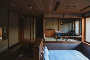 una camera con letto, tavolo e sedie di Sowaka a Kyoto