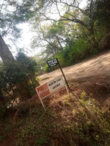 un panneau de rue assis sur le côté d'une route dans l'établissement White Lodge Moshi, à Moshi