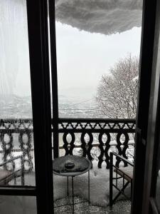 a balcony with a table and a view of a city at Pilioritiko Spiti in Makrinítsa