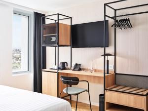 H4 Hotel Wyndham Paris Pleyel Resort tesisinde bir odada yatak veya yataklar