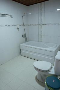 a bathroom with a toilet and a bath tub at Khách Sạn Như Mai in Quang Tri