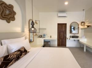 een slaapkamer met een wit bed en een keuken bij El Tropico Boutique Hotel in Kuta Lombok