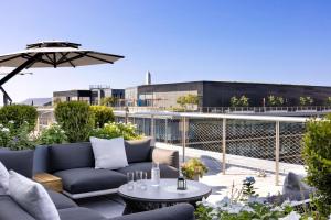 a patio with a couch and an umbrella on a roof at Conrad Washington DC in Washington