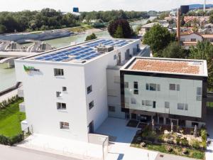 uma imagem de um edifício com painéis solares no telhado em Eco Suite Hotel em Salzburgo