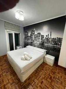 - une chambre avec un lit orné d'une fresque murale représentant la ville dans l'établissement Encantador apartamento en el centro de Castro, à Castro Urdiales