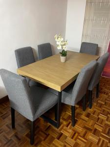 une table en bois avec des chaises et un vase de fleurs. dans l'établissement Encantador apartamento en el centro de Castro, à Castro Urdiales