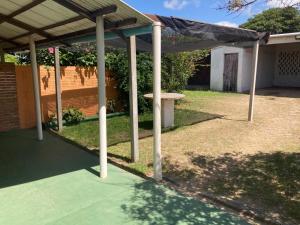 uma pérgola com uma mesa de piquenique num quintal em Rochas em Barra del Chuy