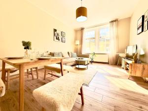 sala de estar con mesa y sofá en Herzraum Appartement,kostenfreier Parkplatz,Innenstadt Babybett,Familie u Buisness,gratis Kaffee und Tee, en Bautzen