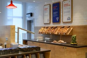 eine Bäckerei mit Körben mit Brot und Gebäck auf der Theke in der Unterkunft Holiday Inn Express Munich Airport - Erding, an IHG Hotel in Erding