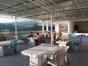 a group of people sitting at tables on a patio at JABAAL GUEST HOUSE and RESTO in Senaru