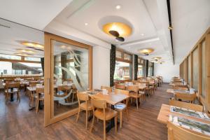 een eetkamer met houten tafels en stoelen bij Jungfrau Lodge, Swiss Mountain Hotel in Grindelwald