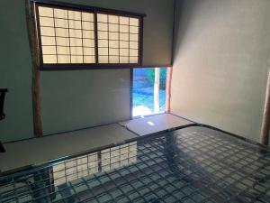 an empty room with a large window and a mattress at 一日限定一組の宿なんでもん in Naoshima