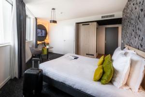 a hotel room with a bed and a suitcase at Nemea Appart Hotel Nice Arenas Aéroport in Nice