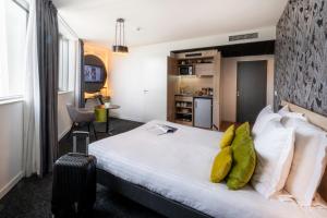 a hotel room with a bed and a suitcase at Nemea Appart Hotel Nice Arenas Aéroport in Nice