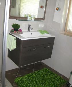 baño con lavabo y alfombra verde en Apartment Galtenberg, en Alpbach