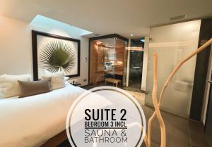 een slaapkamer met een wit bed en een badkamer bij KITZ DELUXE SUITE 1 & 2 im Zentrum mit POOL, eigenem SPA & PARKEN by belle-stay in Kitzbühel