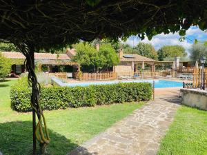 een tuin met een zwembad en een huis bij Villa Vacasio Bio-Eco in Pitigliano