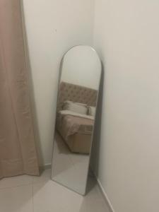 Four Stars Hostel RAS Al-Khaimah في رأس الخيمة: مرآة في غرفة مع سرير فيها