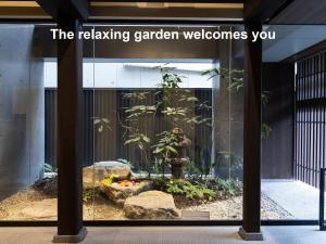 une fenêtre en verre avec un jardin dans un bâtiment dans l'établissement Mitsui Garden Hotel Kyoto Shinmachi Bettei, à Kyoto