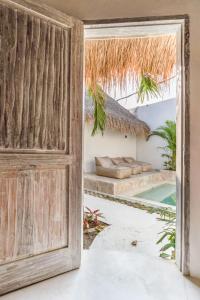 une porte ouverte menant à un complexe avec une piscine dans l'établissement The Stay Padang Padang, à Bingin Beach