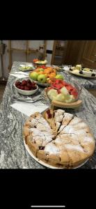 uma mesa coberta com pratos de frutas e tortas em Zara Chalet em Bran