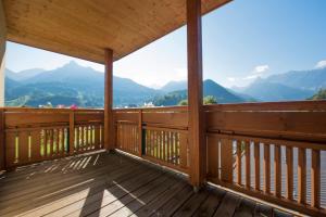 een houten balkon met uitzicht op de bergen bij Hotel Vitalquelle Montafon in Schruns