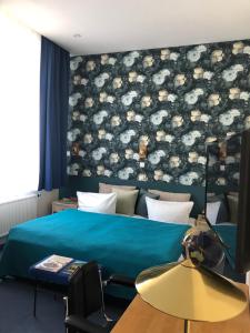 - une chambre avec un lit et une couette bleue dans l'établissement Hotel Villa Hentzel, à Weimar