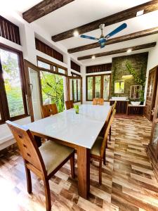 ein Esszimmer mit einem weißen Tisch und Stühlen in der Unterkunft Thottungal Homestay in Ernakulam