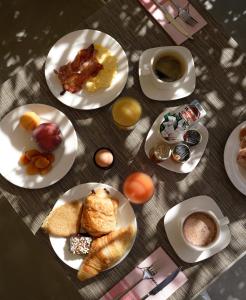 a table with plates of breakfast foods and a cup of coffee at Grand Prix Hôtel & Restaurant in Le Castellet