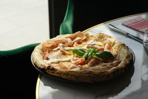 a pizza sitting on a plate on a table at Grand Prix Hôtel & Restaurant in Le Castellet