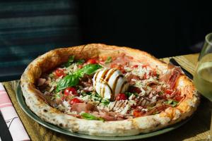 a pizza sitting on a plate on a table at Grand Prix Hôtel & Restaurant in Le Castellet