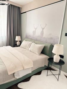 a bedroom with a bed with two deer on the wall at Premium Line Apartman in Sombor