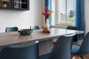 a dining room table with chairs and a vase with flowers at Inselglück in Altefähr