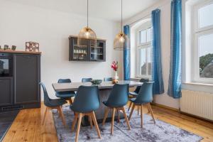 a dining room with blue chairs and a table at Inselglück in Altefähr