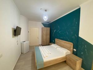 - une chambre avec un lit et un mur bleu dans l'établissement Villa Luan Ksamil, à Ksamil