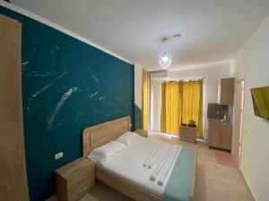 - une chambre avec un lit et un mur bleu dans l'établissement Villa Luan Ksamil, à Ksamil