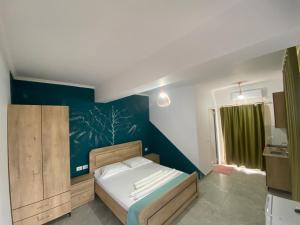 - une chambre avec un lit et un mur bleu dans l'établissement Villa Luan Ksamil, à Ksamil